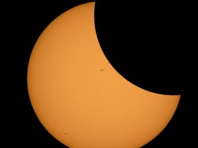 This NASA handout photo shows the Moon seen as it starts passing in front of the Sun during a solar eclipse from Ross Lake, Northern Cascades National Park, Washington on August 21, 2017. A total solar eclipse will sweep across a narrow portion of the contiguous United States from Lincoln Beach, Oregon to Charleston, South Carolina. A partial solar eclipse was visible across the entire North American continent along with parts of South America, Africa, and Europe. / AFP PHOTO / NASA / Bill INGALLS