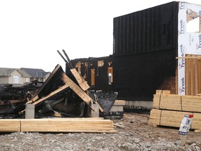 Two homes under construction, and the entire facing wall of a third home were heavily damaged by a suspicious fire on Lawson Road, west of Sandbar Street in London, Ont. (MIKE HENSEN, The London Free Press)