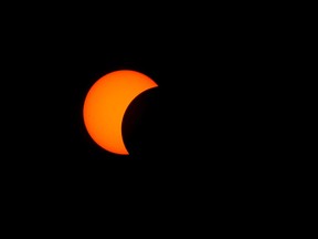 The moon starts to pass across the face of the sun during Monday's solar eclipse, as seen from Kingston. (Elliot Ferguson/The Whig-Standard)