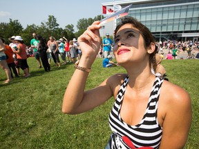Michele Vidal uses an Eclipse Viewer as the partial solar eclipse is observed at an event held by the Royal Astronomical Society at the Canadian Aviation and Space Museum in Ottawa. Photo Wayne Cuddington/ Postmedia