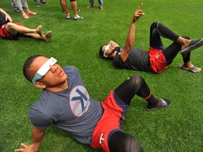 Minnesota Twins players Ehire Adrianza, front, and Ervin Santana, along with other members of the team, watch the solar eclipse before a baseball game between the Minnesota Twins and Chicago White Sox on Aug. 21, 2017. (AP Photo/Paul Beaty)