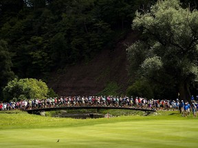 Spectators cross the bridge between the 13th and 14th holes during the Canadian Open at Glen Abbey golf club in Oakville, Ont., on Saturday, July 29, 2017. (THE CANADIAN PRESS/Nathan Denette)