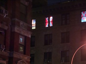 This Aug. 17, 2017 image made from a video shows Confederate flags displayed in the seventh-floor windows of an apartment in the East Village neighborhood of New York. (PIX11 News via AP)