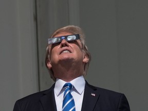 US President Donald Trump looks up at the partial solar eclipse from the balcony of the White House in Washington, DC, on August 21, 2017. / AFP PHOTO / NICHOLAS KAMMNICHOLAS KAMM/AFP/Getty Images