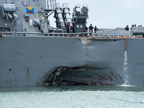 Damage to the portside is visible as the Guided-missile destroyer USS John S. McCain (DDG 56) steers towards Changi naval base in Singapore following a collision with the merchant vessel Alnic MC Monday, Aug. 21, 2017. The USS John S. McCain was docked at Singapore's naval base with "significant damage" to its hull after an early morning collision with the Alnic MC as vessels from several nations searched Monday for missing U.S. sailors. (Mass Communication Specialist 2nd Class Joshua Fulton/U.S. Navy photo via AP)