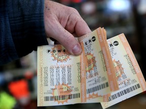 A customer holds a handful of Powerball tickets at Kavanagh Liquors on January 13, 2016 in San Lorenzo, California. Dozens of people lined up outside of Kavanagh Liquors, a store that has had several multi-million dollar winners, to -purchase Powerball tickets in hopes of winning the estimated record-breaking $1.5 billion dollar jackpot. (Justin Sullivan/Getty Images)