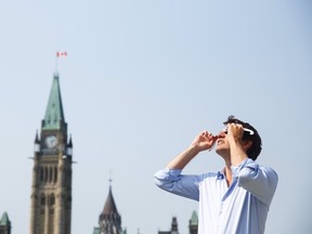 In a photo posted to Twitter, Prime Minister Justin Trudeau looks up at the 2017 solar eclipse from Parliament Hill in Ottawa on August 21, 2017. (Twitter/Justin Trudeau)