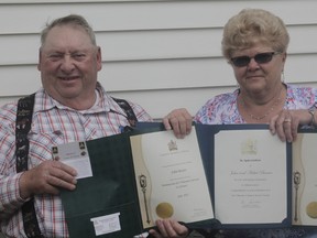 John and Mabel Baxter hold up their certificates recognizing their contributions for volunteering to help seniors (Joseph Quigley | Whitecourt Star).