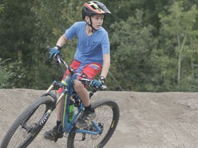 Kyle Strebchuk rides on one of the obstacles at the new Whitecourt Mountain Bike Park on Aug. 20 (Joseph Quigley | Whitecourt Star).