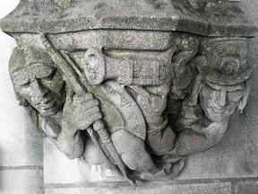 In this May 23, 2013 photo provided by Yale University, a 1929 doorway carving depicts a Puritan settler, right, pointing a musket at the head of a Native American, left, on the school's campus in New Haven, Conn. (Yale University via AP)