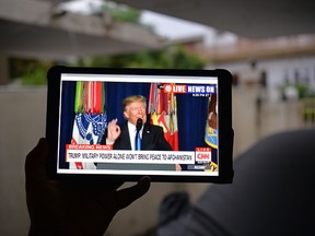 A Pakistani resident watches his tablet in Islamabad on August 22, 2017, showing a live broadcast of U.S. President Donald Trump delivering his address from Joint Base Myer-Henderson Hall in Arlington, Virginia. (Getty Images)