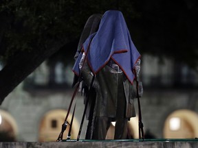 Confederate statutes removed from the University of Texas are secured to a trailer, early Monday morning, Aug. 21, 2017, in Austin, Texas. (AP Photo/Eric Gay)