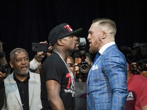 Floyd Mayweather, left, and Conor McGregor exchange harsh words during a promotional tour stop in Toronto on July 12, 2017. (THE CANADIAN PRESS/Christopher Katsarov)