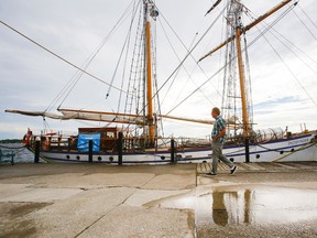 Luke Hendry/The Intelligencer
Brian Diedenhofen, a sailor from Carrying Place, walks past the Toronto tall ship Pathfinder Tuesday at Meyers Pier in Belleville. The late-afternoon sun had just begun to break through the clouds after a day of intermittent and often heavy rainfall. Environment Canada predicts less rain and temperatures around seasonal norms for late August and the fall.