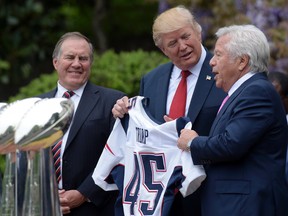 In this April 19, 2017 file photo, President Donald Trump is presented with a New England Patriots jersey from Patriots owner Robert Kraft, right, and head coach Bill Belichick during a ceremony on the South Lawn of the White House in Washington, where the Patriots were honored for their Super Bowl LI victory.  (AP Photo/Susan Walsh, File)