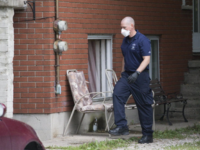 A member of the Barrie police department enters the basement apartment of 12 Coventry Ave. in London, Ont. on Tuesday August 22, 2017. Derek Ruttan/The London Free Press/Postmedia Network