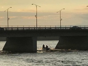 The Ottawa Fire Service water rescue boat heads upstream at Champlain Bridge after a caller saw a green canoe overturn in the Ottawa River early Tuesday even. BLAIR CRAWFORD / POSTMEDIA