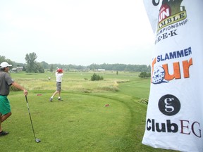 Troy Monaghan tees off from the first hole as he is watched by John De Vroome during the Ottawa Sun Scramble at the Dragonfly Golf Course in Renfrew yesterday. (Jean Levac/Ottawa Sun)