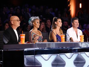 In this Tuesday, Aug. 22, 2017 photo provided by NBC, judges Howie Mandel, Mel B, Heidi Klum and Simon Cowell participate in a live broadcast of "America's Got Talent" in Los Angeles. Mel B threw a cup of water on Cowell and walked off the stage after Cowell made a joke about her wedding night during the show. (Trae Patton/NBC via AP)