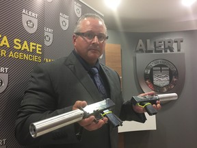 Alert acting inspector Pierre Blais with some of the guns seized. (Photo by Larry Wong/Postmedia)