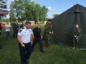Public Safety Minister Ralph Goodale, in black, tours the tent city constructed outside the Nav Centre in Cornwall, Ont., after meeting with the city council to discuss their concerns about how the operation to house asylum seekers is being run. (Handout/Cornwall Standard-Freeholder/Postmedia Network)