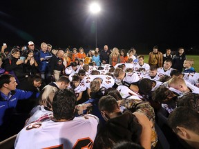 In this Oct. 16, 2015 file photo, former Bremerton High School assistant football coach Joe Kennedy, obscured at center, is surrounded by Centralia High School football players in Bremerton, Wash., after they took a knee with him and prayed following their game against Bremerton. (Meegan M. Reid/Kitsap Sun via AP)