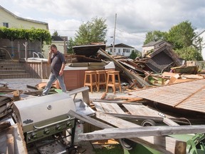 Michel Laurin surveys the damage to his backyard from a category one tornado Wednesday in Lachute, Que. northwest of Montreal.
Canadian Press