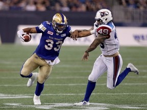 Winnipeg Blue Bombers running back Andrew Harris (33) stiff arms Montreal Alouettes linebacker Dominique Tovell (49) during second half CFL football action, in Winnipeg on Thursday, July 27, 2017. THE CANADIAN PRESS/Trevor Hagan