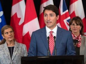 Prime Minister Justin Trudeau, flanked by Laura Albanese, left, Ontario Minister of Citizenship, and Kathleen Weil, Quebec Minister of Immigration, Diversity and Inclusiveness, responds to questions following a meeting of the Intergovernmental Task Force on Irregular Migration Wednesday, August 23, 2017 in Montreal. (THE CANADIAN PRESS/Paul Chiasson)