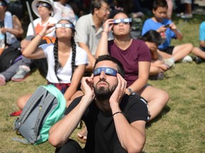 Observers watch the solar eclipse at the Canadian National Exhibition in Toronto on Monday, Au. 21, 2017. (THE CANADIAN PRESS/PHOTO)
