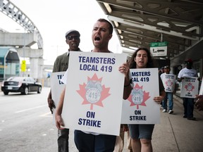 Striking workers are seen picketing at Pearson International Airport in Toronto on Friday, July, 28, 2017. (THE CANADIAN PRESS/Christopher Katsarov)