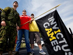 (left to right) Invictus Games flag bearer Master Corporal Joel Gagne, Invictus Games competitor Sgt. Lorne Ford, and Invictus Games flag bearer Master Warrant Officer (retired) Mark DesRoches pose for a photo as the Invictus Games National Flag Tour makes a stop at CFB Edmonton, Thursday Aug. 24, 2017. Photo by David Bloom