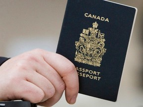 A passenger holds his Canadian passport before boarding a flight to the United States, at the Ottawa airport on Tuesday Jan 23, 2007. THE CANADIAN PRESS /Tom Hanson