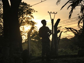 In this Friday, July 14, 2017, photo, a border patrol stands guard at a police post that was previously attacked by a Muslim terrorist group in Kyee Kan Pyin, Buthidaung, Rakhine state Myanmar. (AP Photo/ Esther Htusan)