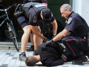 Police arrested a man on Market Lane, between Dundas Street and Covent Market Place,  in downtown London Friday. Another man was also arrested nearby.  (DALE CARRUTHERS, The London Free Press)