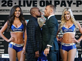 Floyd Mayweather Jr., center left, and Conor McGregor pose for photographers during a news conference Wednesday, Aug. 23, 2017, in Las Vegas. (AP Photo/John Locher)