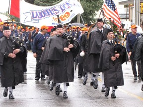 Pipebands and marchers came ready for the weather in this 2011 Labour Day Parade file photo. About 40 entries and thousands of participants are set to march Sept. 4 in Sarnia. (Observer file photo)