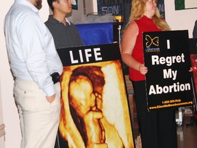 Staff from the Canadian Centre for Bio-Ethical Reform stand with signs in 2013 that they used to convince people to not have an abortion. Pro-life posters often contain graphic images, such as bloody and dismembered fetuses, in an effort to shock people. (Sun files)