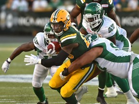 Edmonton Eskimos Pascal Lochard (25) is tackled by Saskatchewan Roughriders during CFL action at Commonwealth Stadium on Friday. (Ed Kaiser)