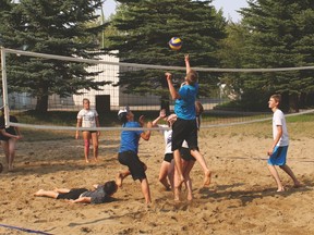 A volleyball camp was held last week. Here, Will Smith jumps to hit the ball onto the other side of the net at the sand court by the pool.