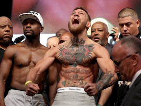 UFC lightweight champion Conor McGregor (R) screams after the face off with Floyd Mayweather Jr. during their official weigh-in at T-Mobile Arena on August 25, 2017 in Las Vegas, Nevada. (Christian Petersen/Getty Images)
