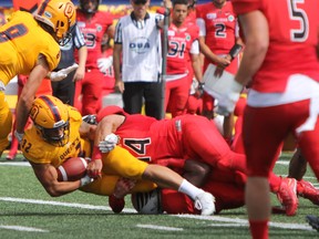 Queen's Golden Gaels running back Jonah Pataki is taken down by Carleton Ravens' Leon Cenerini during the second half of Ontario University Athletics football action at Richardson Stadium in Kingston, Ont., on Saturday, Aug. 26, 2017. The Ravens defeated the Gaels, 22-17. Steph Crosier/Kingston Whig-Standard/Postmedia Network