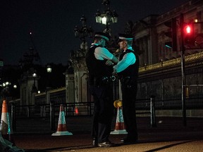Police officers stand guard at a police cordon next to Buckingham Palace following an incident where a man armed with a knife was arrested outside the palace following a disturbance in London on Aug. 26, 2017. (CHRIS J. RATCLIFFE/AFP/Getty Images)