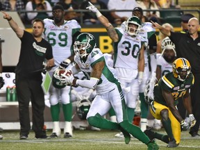 Saskatchewan Roughriders Kacy Rodgers II (45) intercepts the ball on Edmonton Eskimos Bryant Mitchell (80) and runs it in for a touchdown during CFL action at Commonwealth Stadium in Edmonton, August 25, 2017.