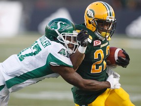 Saskatchewan Roughriders' Crezdon Butler (17) tackles Edmonton Eskimos' LaDarius Perkins (22) during first half CFL action in Edmonton, Alta., on Friday August 25, 2017.