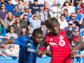 TFC's Chris Mavinga heads the ball away from Montreal's Chris Duvall during Sunday's game. (THE CANADIAN PRESS)