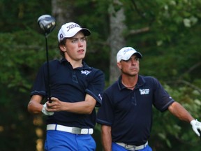 Hunter McGee, 16, hits a drive while his father and playing partner Allen McGee watches yesterday. The duo won their third consecutive Sun Scramble title. (PATRICK DOYLE/Postmedia Network)