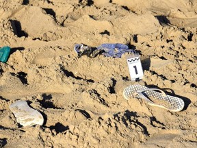 A pair of beach slippers lie on the sand where a suspected gang rape of a Polish tourist and the beating of her partner took place in Rimini, Italy, on Saturday, Aug. 26, 2017. (Manuel Migliorini/ANSA via AP)