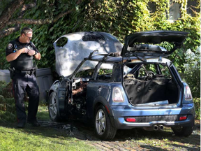 Ottawa police look at a burnt our car on Letchworth Road in Ottawa Ontario Monday Aug 28, 2017. Ottawa fire put the fire out Monday morning with out the fire spreading to the house.  (Tony Caldwell, Postmedia)