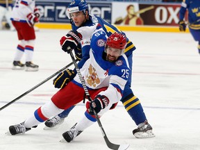 This May 24, 2014 file photo shows Russia forward Danis Zaripov, bottom, being challenged by Sweden forward Joakim Lindstrom during a semifinal match at the Ice Hockey World Championship in Minsk, Belarus. (AP Photo/Darko Bandic, file)